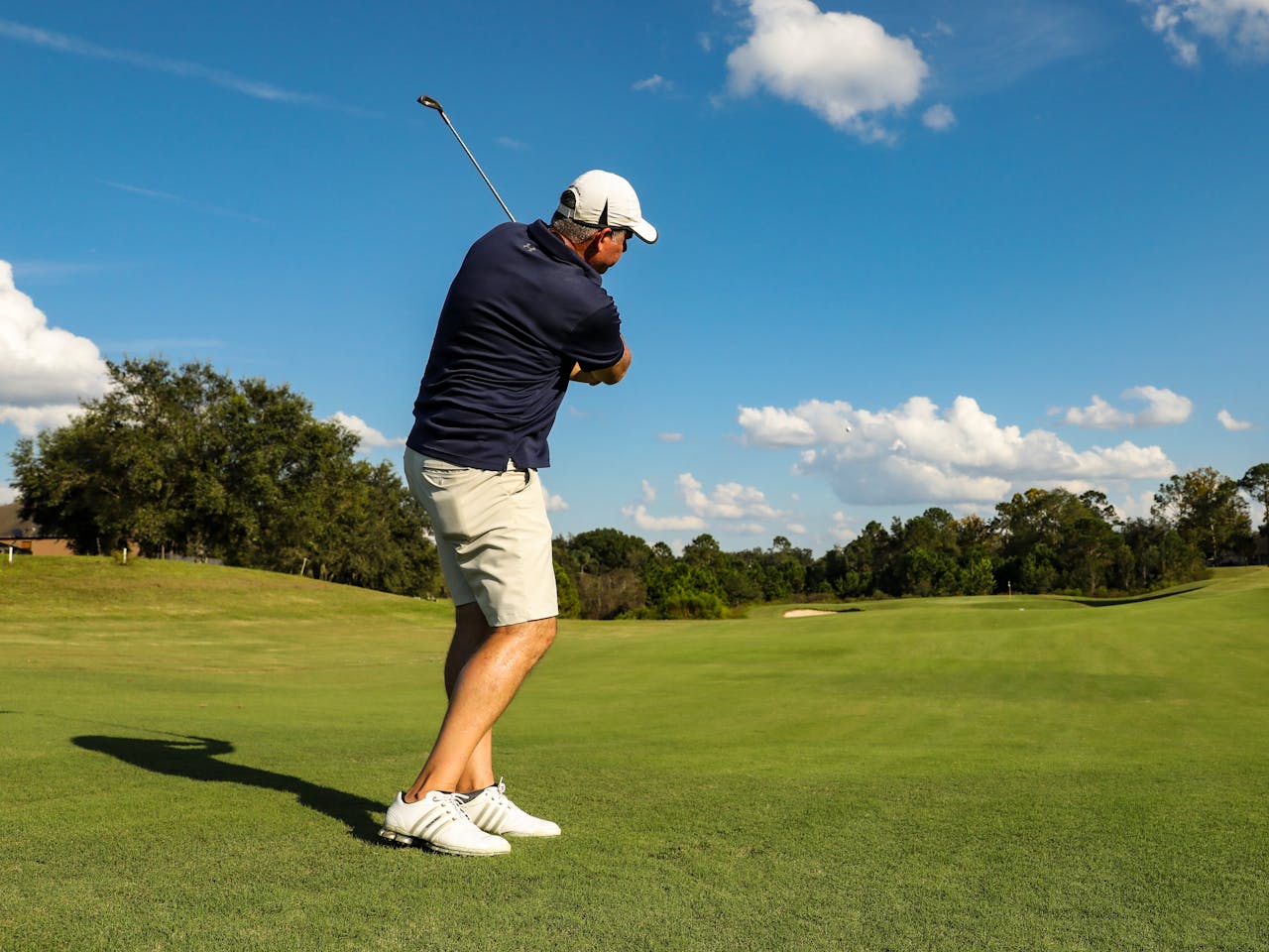 Golfer mid-swing on a course